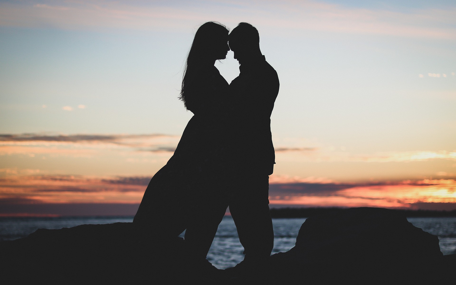 Pareja besándose en la playa.