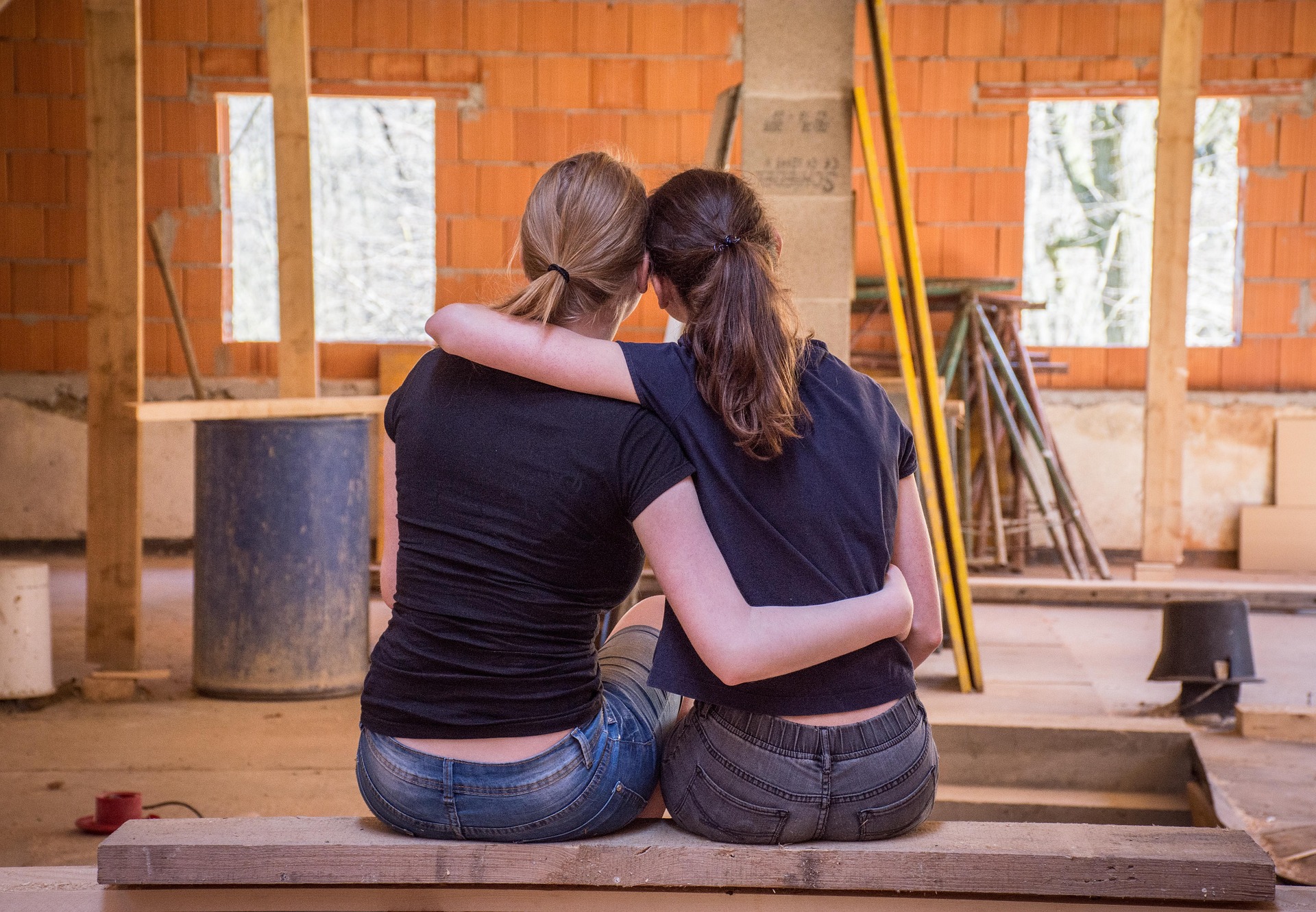 Pareja de chicas abrazadas en un proyecto